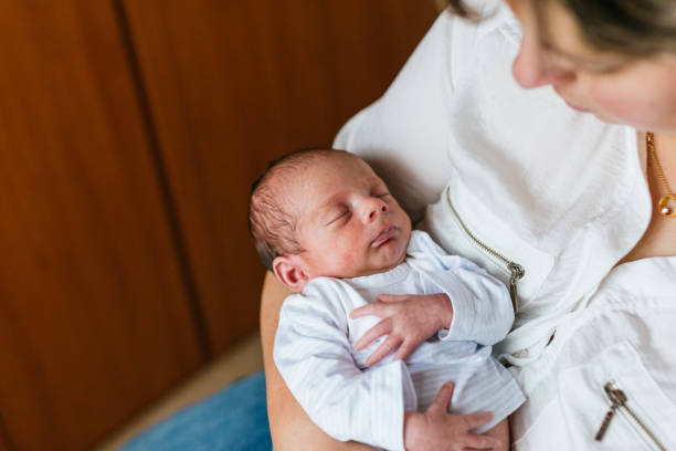 istock Mother holding her newborn baby at home 2189552421