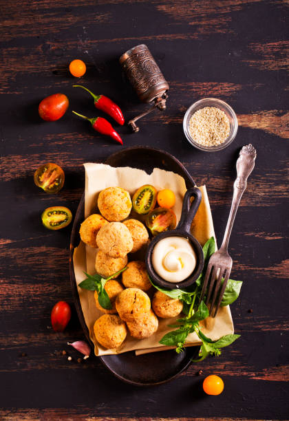 istock Fork with delicious falafel balls, sauce and vegetables on grunge background 2189553913