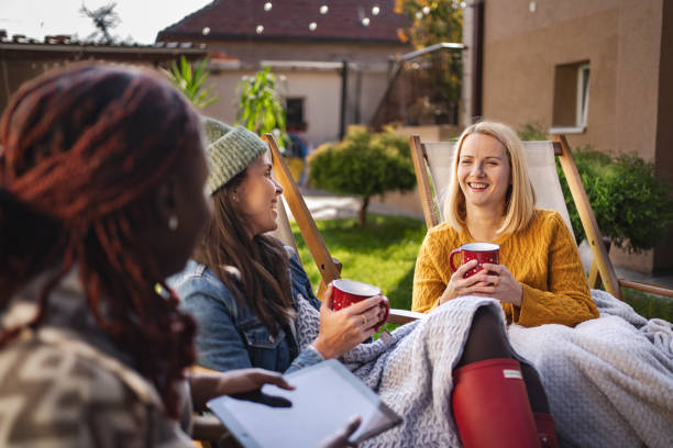 istock Three female friends relaxing, drinking tea, and chatting in backyard 2189554988