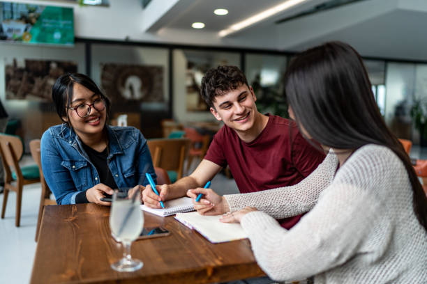 istock Cheerful friends study together in coffee shop 2189555163