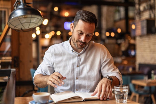 istock Businessman in a cafe - Sipping coffee and writing ideas 2189557027
