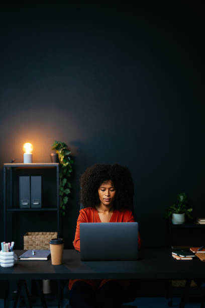 istock Focused young woman working late on laptop in modern office 2189558091