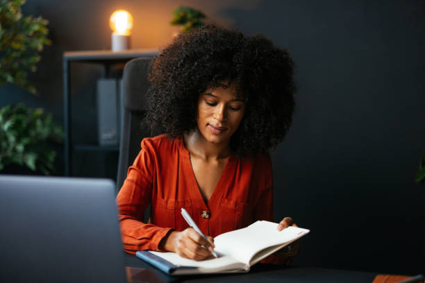 istock Young businesswoman taking notes in her modern office 2189558094