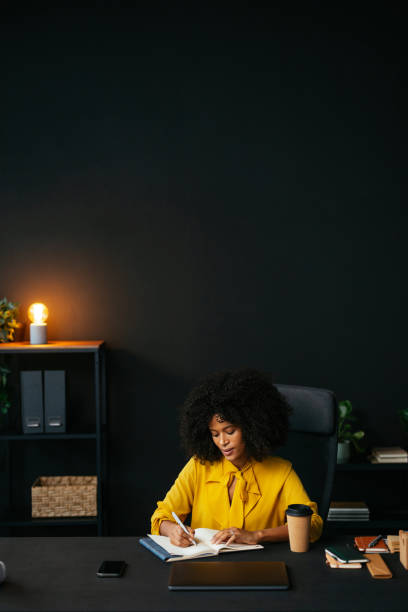 istock Focused businesswoman writing in notebook at desk in modern office 2189558181