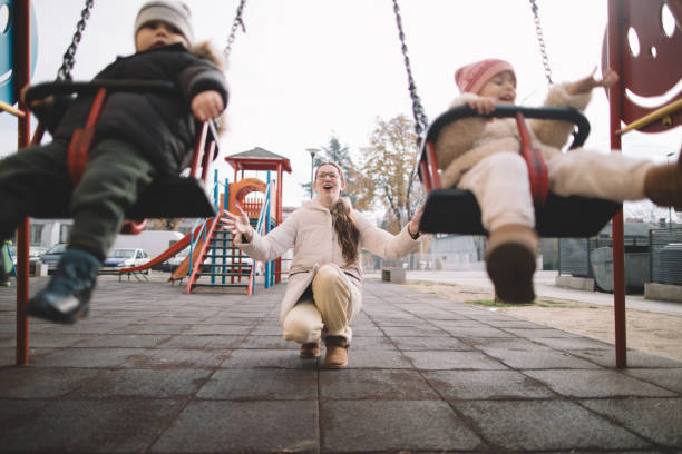 istock Mother pushing kids on the swing 2189559101