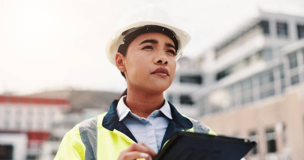 istock Woman, engineer and construction site with tablet, planning and thinking for project or development. Female person, technology and helmet for safety, infrastructure and industry as inspection expert 2189559160