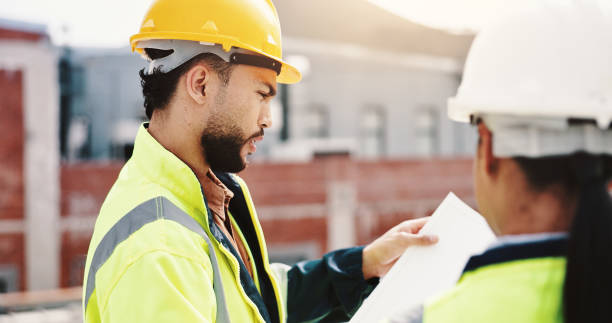 istock Reading, construction site or people with blueprint for inspection, urban development or planning in city. Man, woman or contractors with floor plan paperwork for town building layout or architecture 2189559171