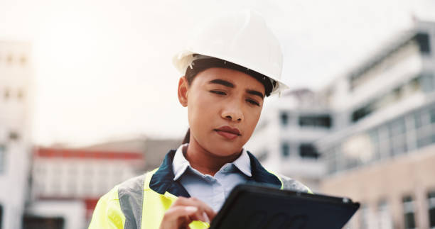 istock Woman, helmet and construction site with tablet, outdoor and architecture for development project. Female person, technology and engineer for safety, infrastructure and industry as inspection expert 2189559174