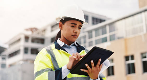 istock Woman, engineer and construction site with tablet, outdoor and planning for project or development. Female person, technology and helmet for safety, infrastructure and industry as inspection expert 2189559195