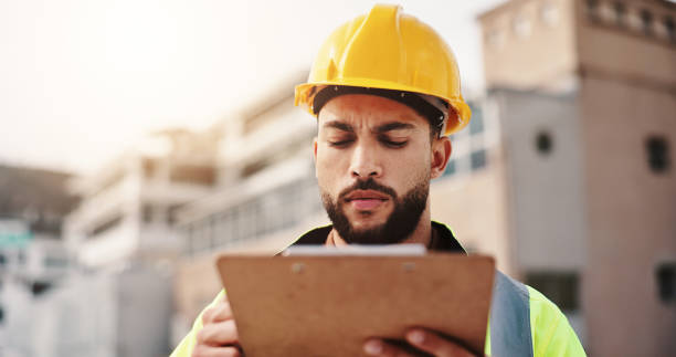 istock Clipboard, engineer and inspection with man in city for architecture, building or planning. Construction site, contractor and project manager with person in outdoor for urban development update 2189559216