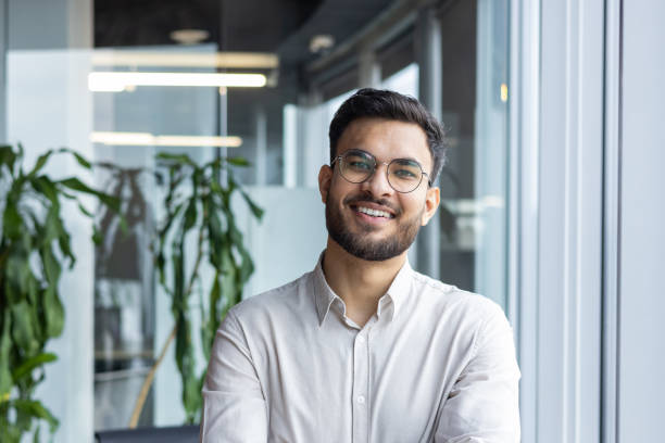 istock Confident young professional in modern office environment smiling at camera 2189559803