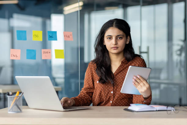 istock Businesswoman working with laptop and tablet in modern office setting 2189562237