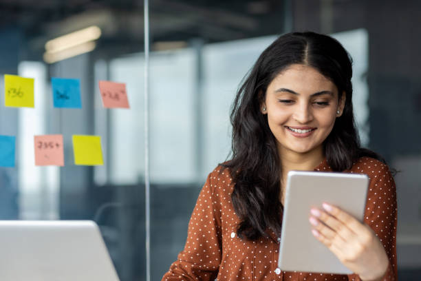 istock Businesswoman using a tablet device in a modern office setting 2189562710