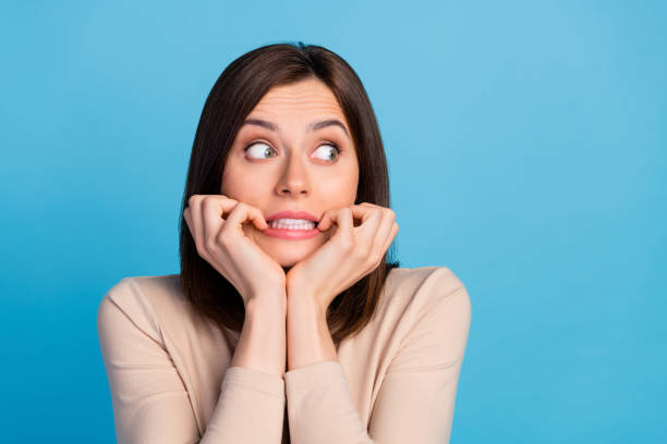 istock Photo of terrified person teeth biting nails look interested empty space isolated on blue color background 2189563409