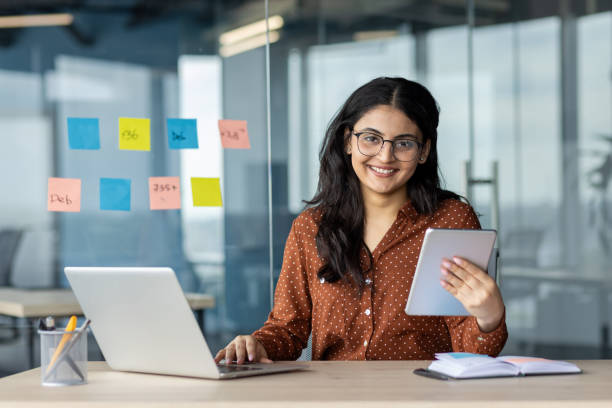 istock Confident businesswoman using technology with a tablet and laptop at work 2189563893