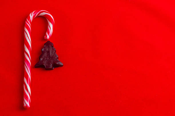 istock Christmas card concept, lollipop and chocolate tree on red background 2189566390