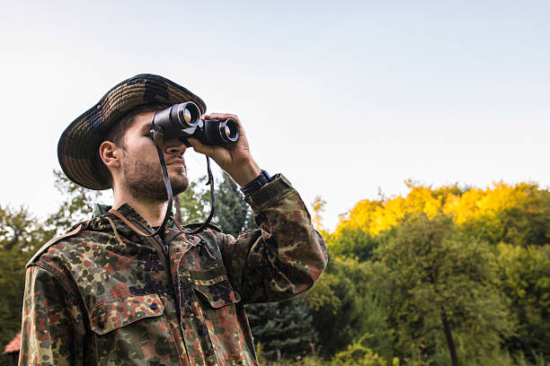 istock Soldier observing with binoculars in forest during military operation 2189568040