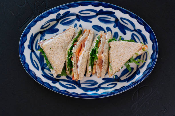 istock Three delicious smoked salmon sandwiches are artfully arranged on a plate. 2189568953