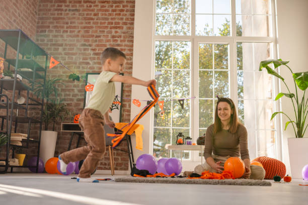 istock Mother and child creating vibrant Halloween decorations in a sunlit modern home 2189579045