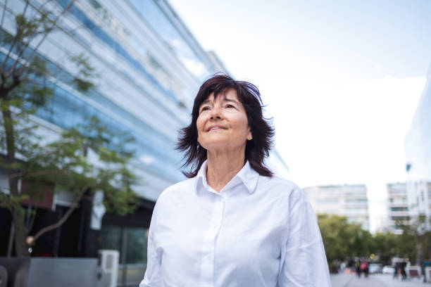 istock Confident mature woman enjoying a stroll in a modern urban environment 2189579165