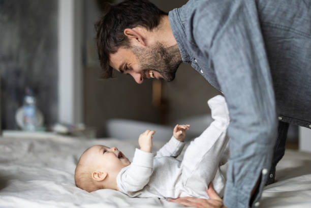 istock Father on paternity leave looking after his infant son at home 2189580715