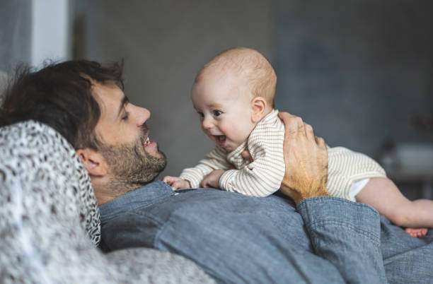 istock Father on paternity leave looking after his infant son at home 2189580732