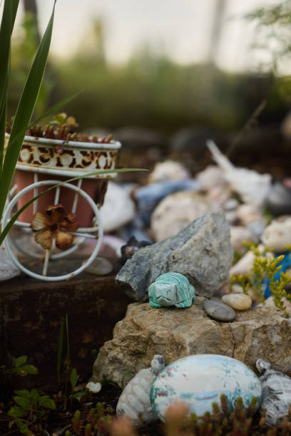 A beautiful and delightful garden scene that showcases decorative pieces, colorful pebbles, and lush greenery