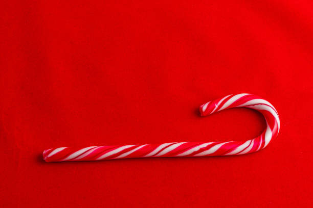 Red and white cane lollipop on red background, Christmas concept High quality photo.