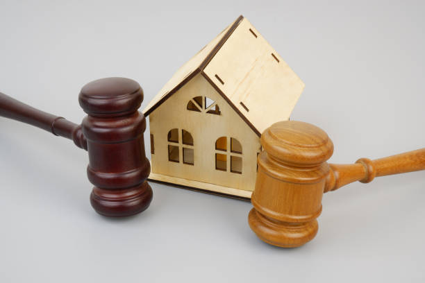 istock Two different wooden gavels and house model on gray background. 2189583406