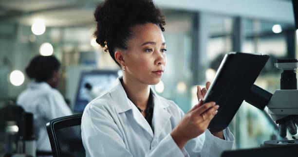 istock Woman, tablet and scientist in lab for typing notes, research and study on genetic analysis. Female person, biology investigation and internet for experiment update, check science and night for plan 2189583454