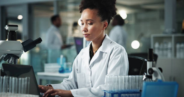 istock Scientist, woman and laptop with notes for biochemistry, experiment and pathology research. Microscope, biotechnology and report for laboratory, pharmaceutical development or genetic DNA study 2189583470