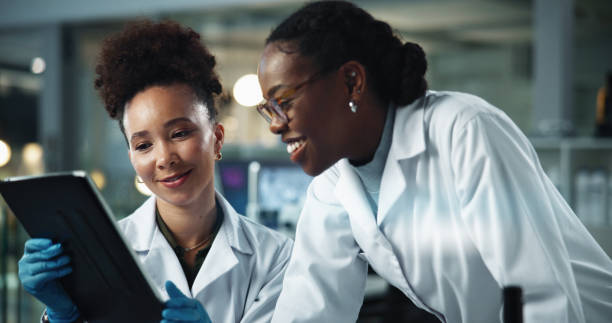istock Science, women and smile in lab with tablet, feedback and scientific breakthrough at night. Research team, tech and happy in facility for deadline advice, pharmaceutical development or study with app 2189583494