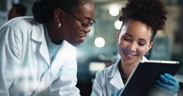 istock Science, women and smile in lab with tablet, feedback and scientific innovation at night. Research team, tech and pleased with results in facility for advice, pharmaceutical development and overtime 2189583495