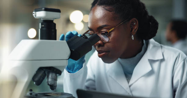istock Black woman, scientist and microscope research for laboratory and medical study with pharma investigation. Virus, staff and vaccine testing for health science with working healthcare professional 2189583517