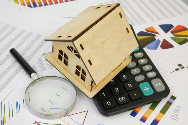 istock House model with calculator and magnifying glass on financial data. 2189583684