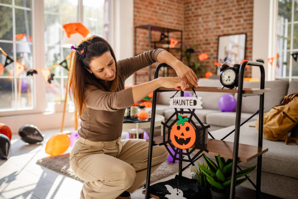 istock Woman Decorating Home Interior with Halloween Decor Celebrations 2189583903