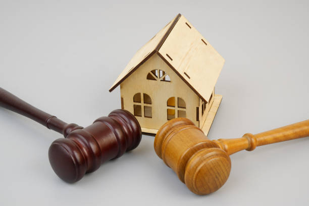 istock Two different wooden gavels and house model on gray background. 2189584057