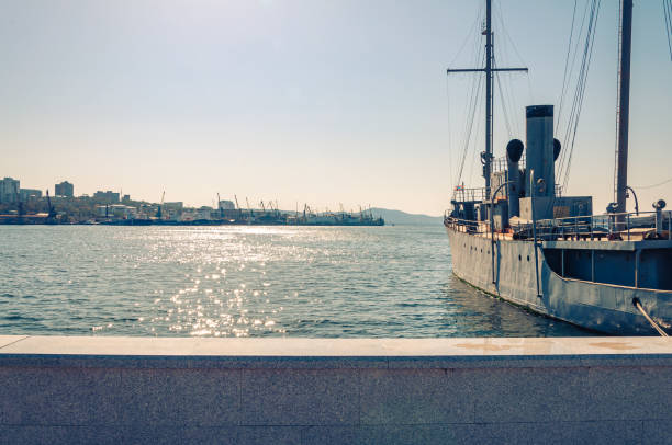 Vladivostok, Russia - October 21, 2012: A historic ship docked at the harbor with the city skyline in the background.