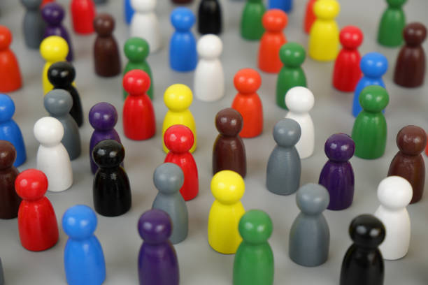 istock Many different colored wooden figures standing close to each other on gray background. 2189585971