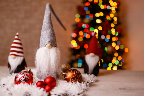 istock Festive Christmas Gnome Decorations with Ornaments and Bokeh Christmas Tree in Background 2189586541