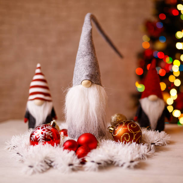 istock Festive Christmas Gnome Decorations with Ornaments and Bokeh Christmas Tree in Background 2189586570