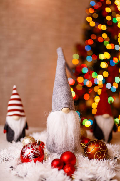 istock Festive Christmas Gnome Decorations with Ornaments and Bokeh Christmas Tree in Background 2189586607