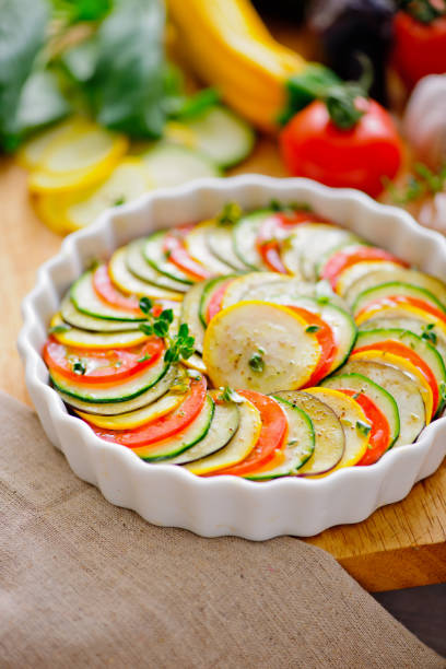 Ingredients for Ratatouille Layered in Ceramic Dish with Fresh Zucchini, Tomatoes, and Eggplant