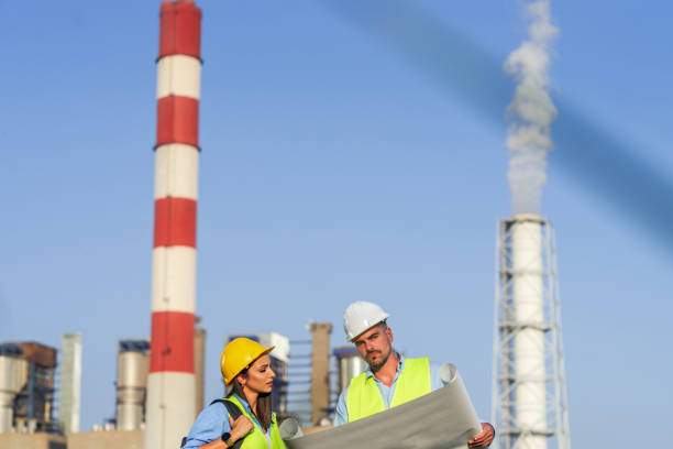 istock Engineers discussing plans at power plant with smoking chimneys 2189591437