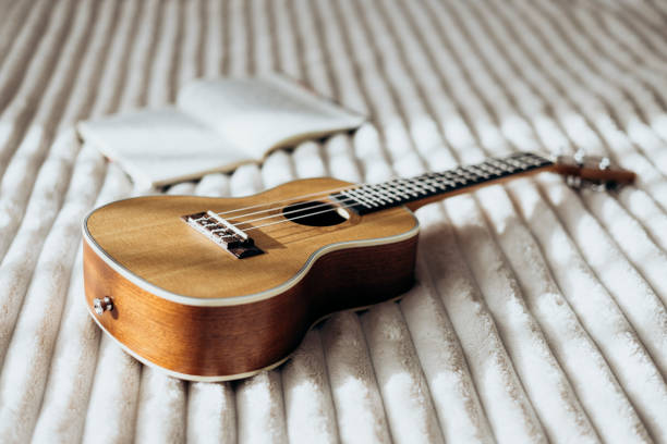 istock Ukulele guitar and open notebook on white bed, atmosphere for writing music. 2189591768