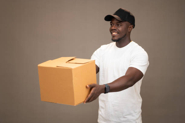 istock Young Black American Dispatch Rider Handing Out Packages with a Smile 2189593902