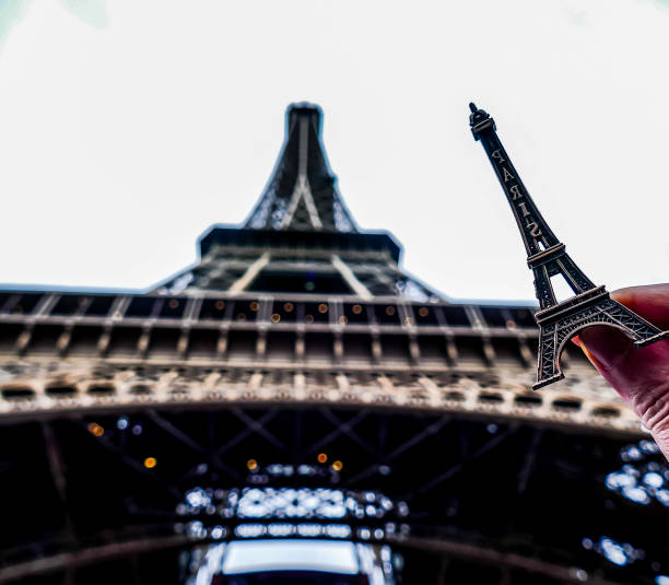 istock A hand holding a small replica of the Eiffel Tower 2189594566