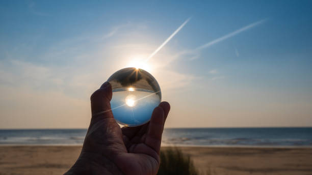 istock Beach and sea reflected in a ball in a human hand 2189595668