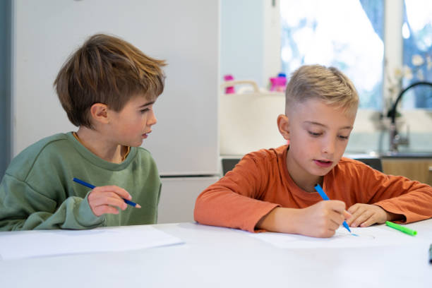 istock Two young boys drawing with colored pencils at home, improving creativity and imagination 2189597649