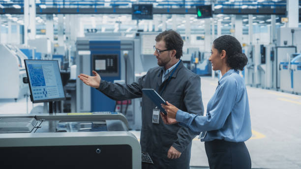 istock Caucasian Male Chief Engineer And Hispanic Female Supervisor Using Tablet And Talking At Electronics Factory. Man Using Soldering Jet Printer, Explaining Process Behind Production Of Microchip. 2189597760